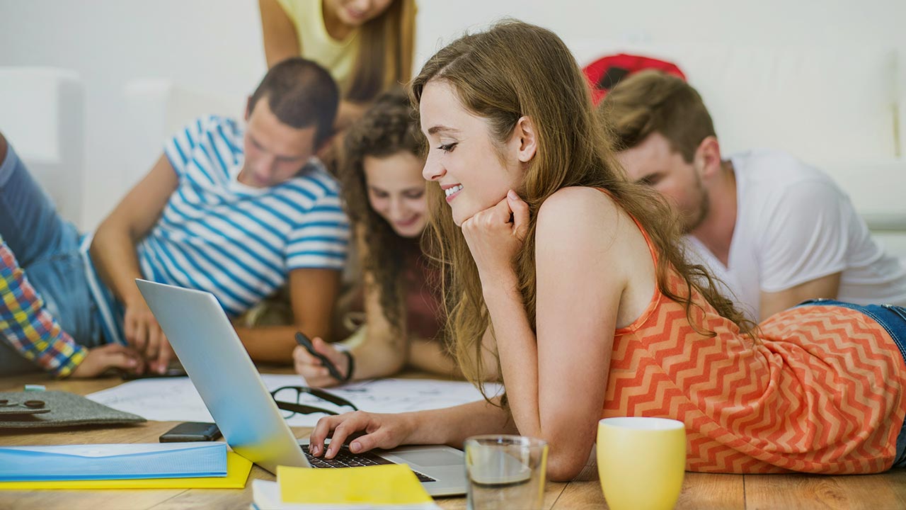 Gruppe von Personen liegt auf dem Boden und arbeitet gemeinsam mit Laptops und Schreibzeug an einem Projekt ©  Unsplash+ 