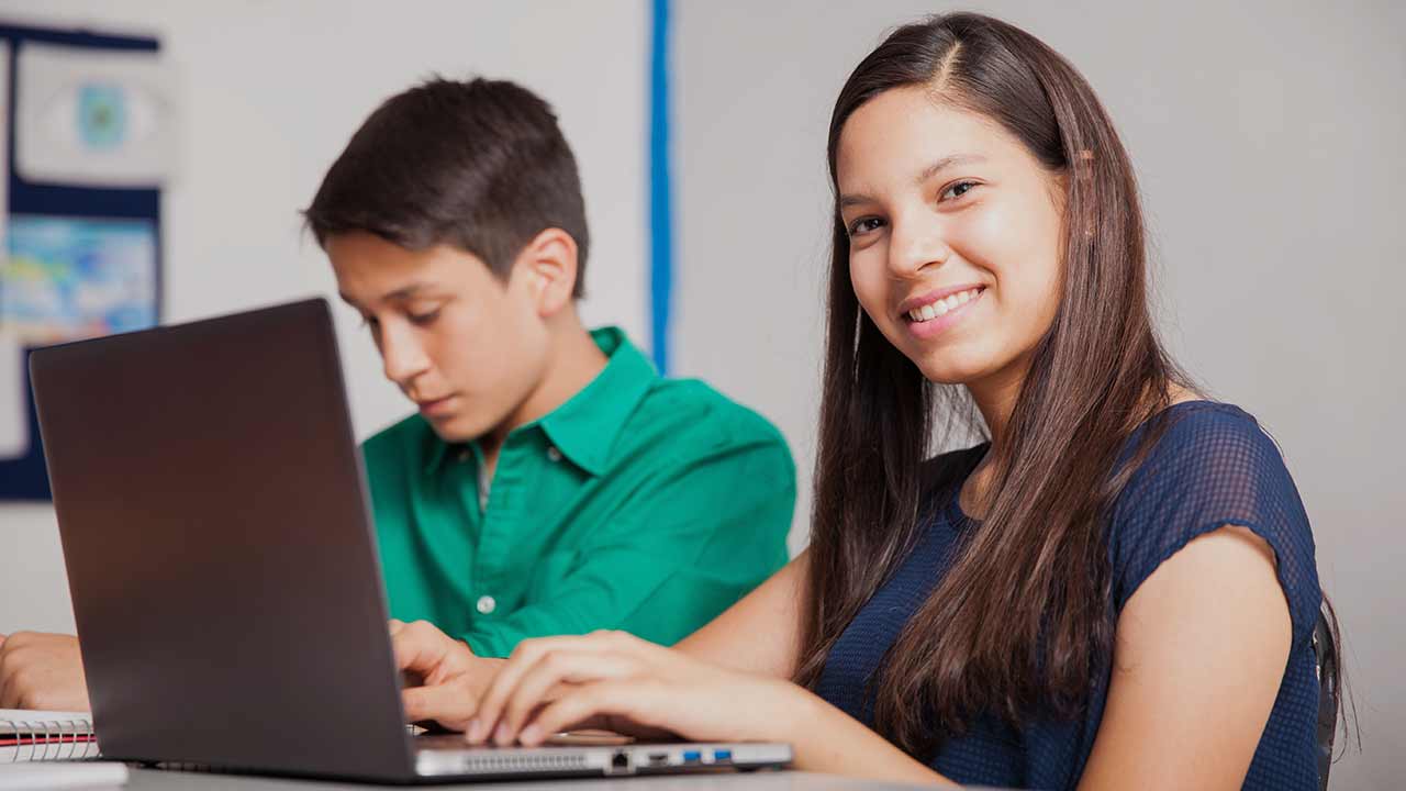 Mädchen und Junge sitzen vor einem Laptop