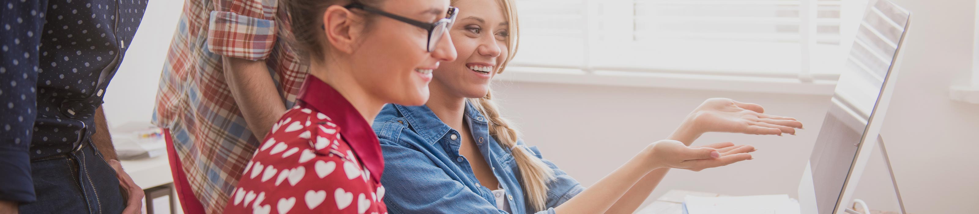 zwei Frauen sitzen vor einem Laptop 