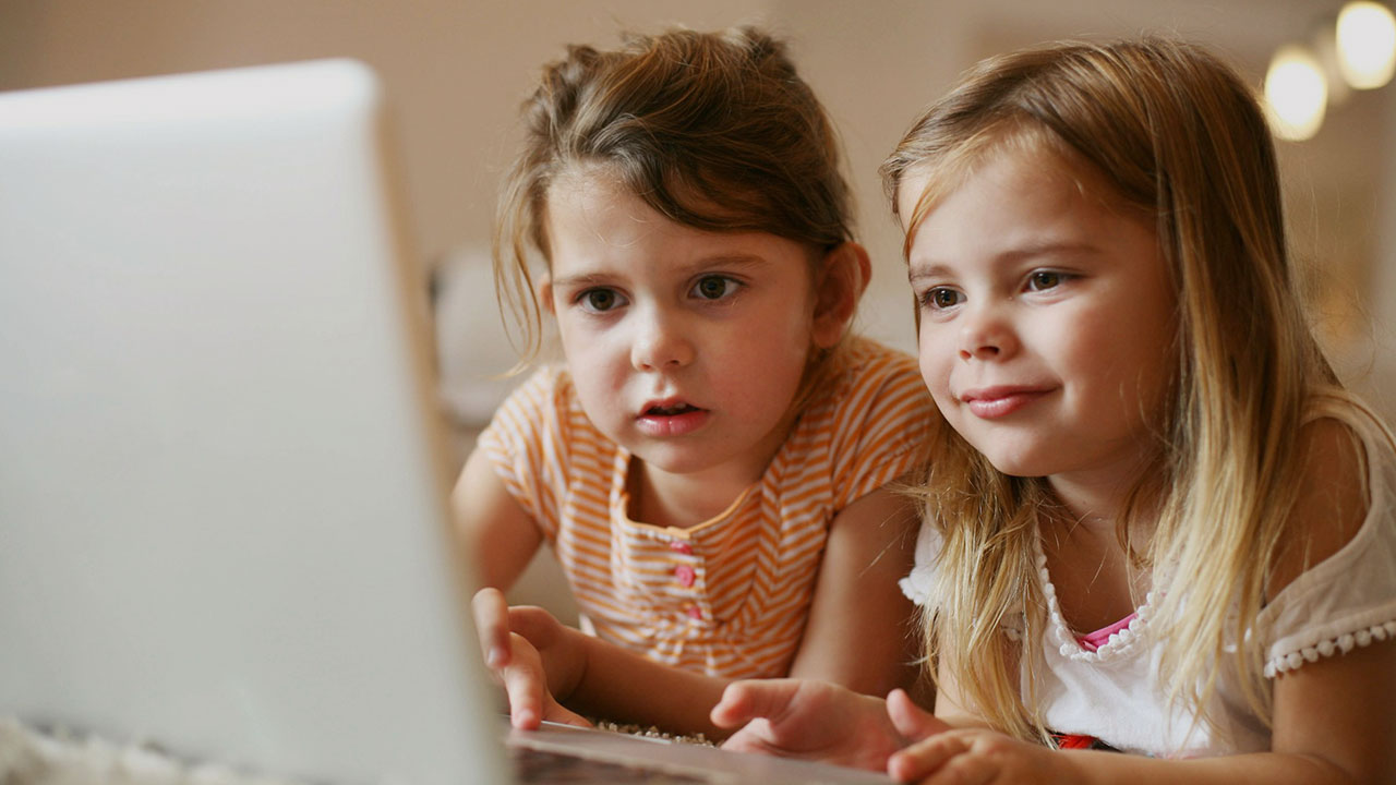 Zwei Mädchen sitzen vor einem Laptop